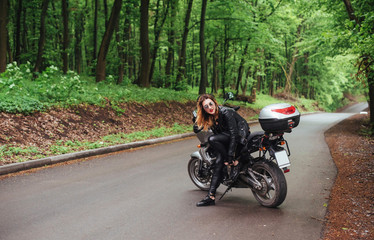 Fototapeta na wymiar An attractive sexy girl on a sports motorbike posing outside