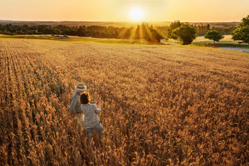 Farmer couple standing in their wheat field at sunset © jackfrog