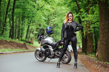 Obraz na płótnie Canvas An attractive sexy girl on a sports motorbike posing outside