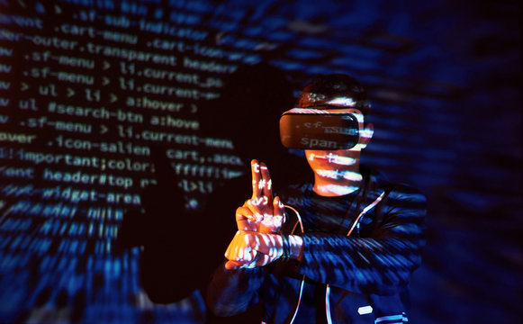 Cyber attack with unrecognizable hooded hacker using virtual reality, digital glitch effect