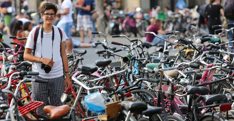 Stickers fenêtre Amsterdam Amsterdam et jeune touriste au milieu du parking avec des milliers