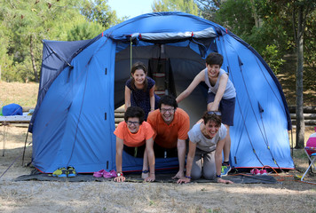 five-person family with three children with camping tent in summ
