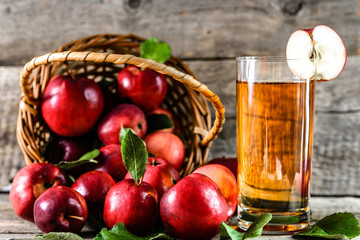Delicious apple juice in a cup and red apples on wooden table, organic food and healthy lifestyle concept