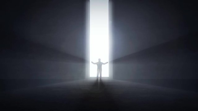 Man standing at an opening light tunnel's entrance raising his hands up