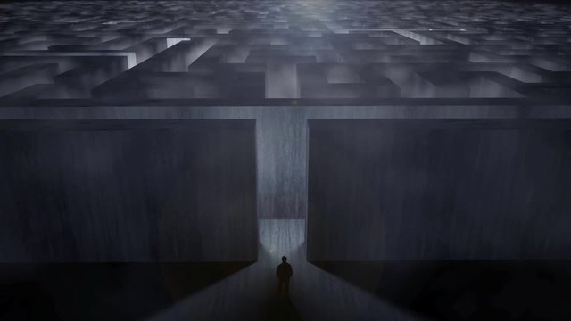 Man standing at a gigantic labyrinth in a dramatic environment with fog - challenge concept