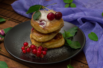 Pancakes with cherries. Wooden background. Close-up. Top view