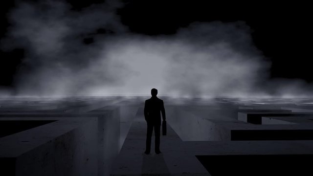 Businessman standing on the top of a labyrinth with dramatic background and fog