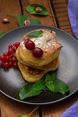 Pancakes with cherries. Wooden background. Close-up. Top view