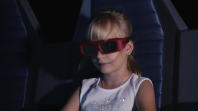 The viewer in a 3-D cinema with movable seats. The girl is watching a movie