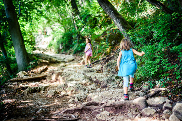 Naklejka na ściany i meble Children - twin girls are hiking in the mountains.