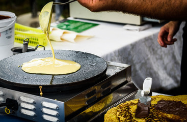 Making of crepes pancakes in open market festival fair.