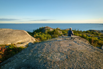 Woman on a bench watching the ocean