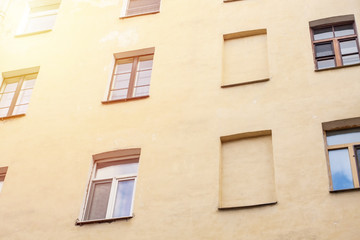 Fototapeta na wymiar Windows on yellow wall of european appartments.