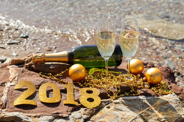 Champagne on a stony beach by the sea, New Year celebrate preparation concept.