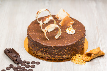 Nut chocolate cake with biscuits and nuts on the table