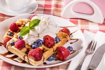 Belgian waffles with whipping cream and fresh berries