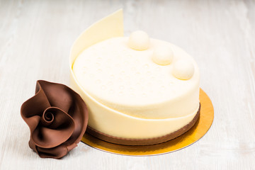 The white chocolate cake and rose on the table