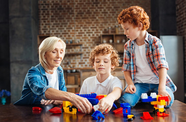 Loving grandmother playing with kids at home