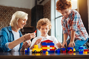 Joyful elderly lady spending time with grandchildren