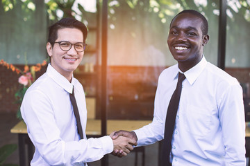 African and asian business man shaking hand with happy and smile.