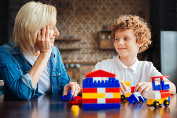 Smart curly haired kid spending time with grandmother