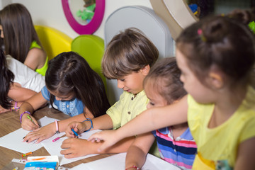 Children drawing on a class in a preschool.