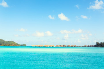 Stunning view of blue turquoise lagoon and far bungalows on background of Bora Bora island, French Polynesia