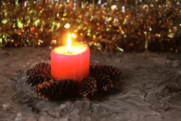 Burning red candle on Christmas decoration background.
