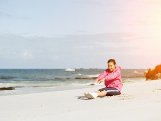 Young woman at the beach doing exercises