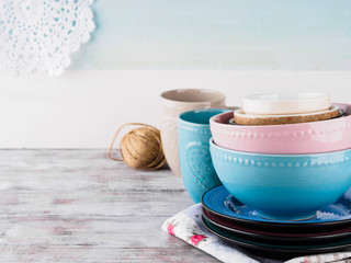 Ceramic crockery tableware on wooden background. Pastel vintage color bowls, dishes, cups
