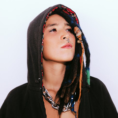 Latin girl with dreadlocks and piercings. In a black hoodie. Street fashion style