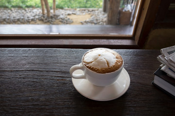 Coffee cup at coffee shop on glasses table with old vintage wooden window background.