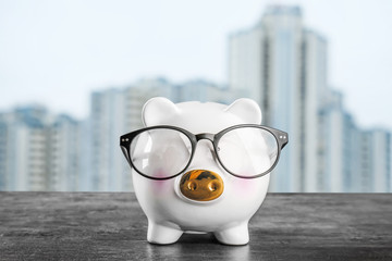 Piggy bank with glasses on table. Mortgage concept