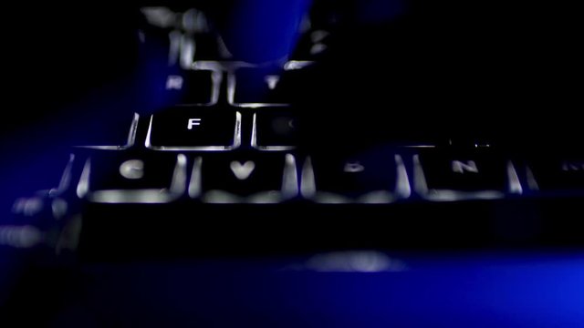 Typing on Illuminated Computer Keyboard in Office at Night, Close Up 