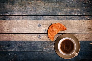 Cup of coffee with croissant and flag