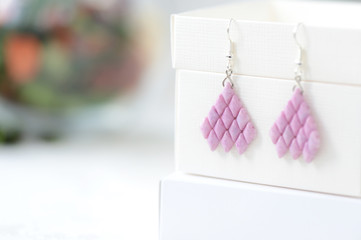 Woven earrings made of pink color beads close up