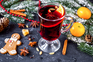 Christmas mulled wine with spices in cup on dark background