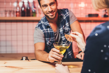 barman giving cocktail to visitor