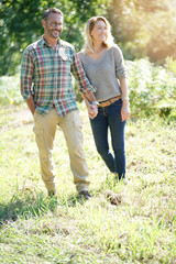 Happy mature couple walking in countryside on sunny day