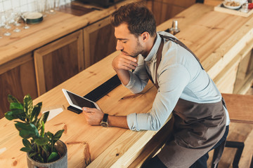 barista using tablet in coffee shop