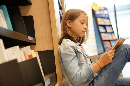 Young Girl In Book Store Reading Comics