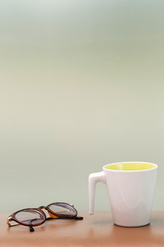 cup and eyeglass on the table