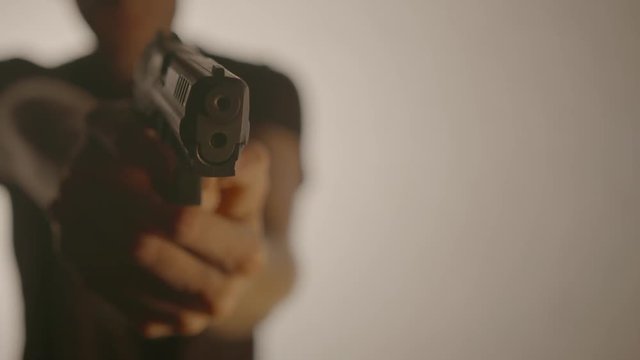 Man Aiming Pistol Gun at Camera