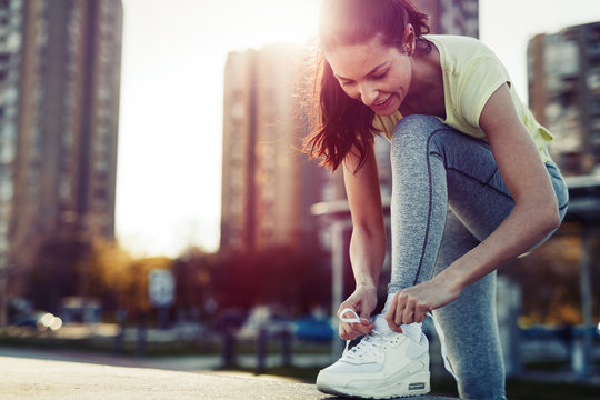 Attractive sportswoman tying shoelace and getting ready for fitness