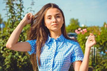 A young sweet woman dressed in a long dress in a blue cage enjoys this day in the garden on a warm sun. Young and beautiful 