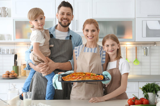 Family with pizza in kitchen. Cooking classes concept