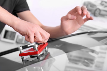 Specialist fixing crack on car windshield in repair shop