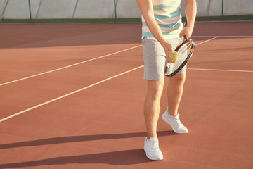 Fototapeta na wymiar Young man playing tennis on court