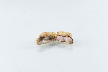 Roasted in shell peanuts scattered on a white background