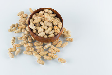 Peanuts in wooden bowl on isolated white background